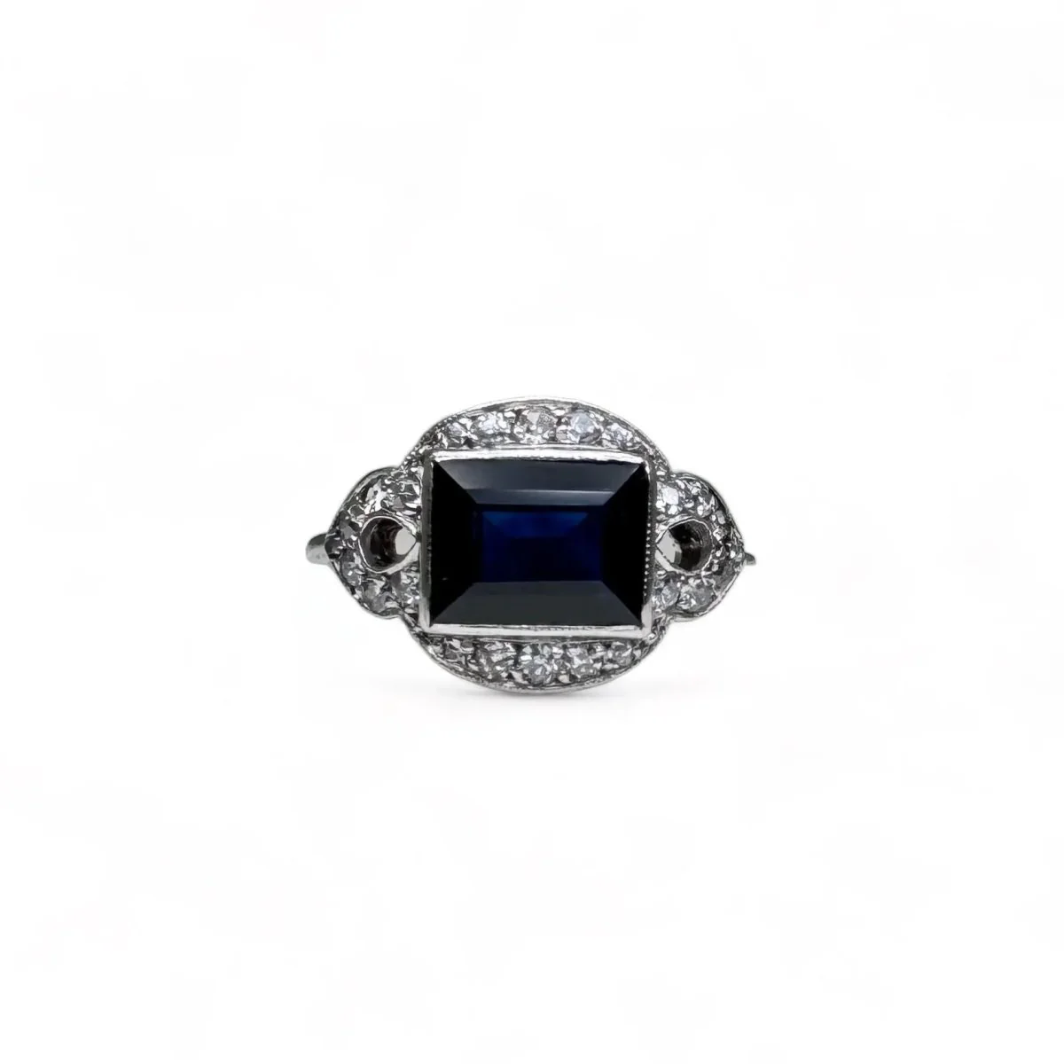 Platinum ring centered with a sapphire surrounded by diamonds.